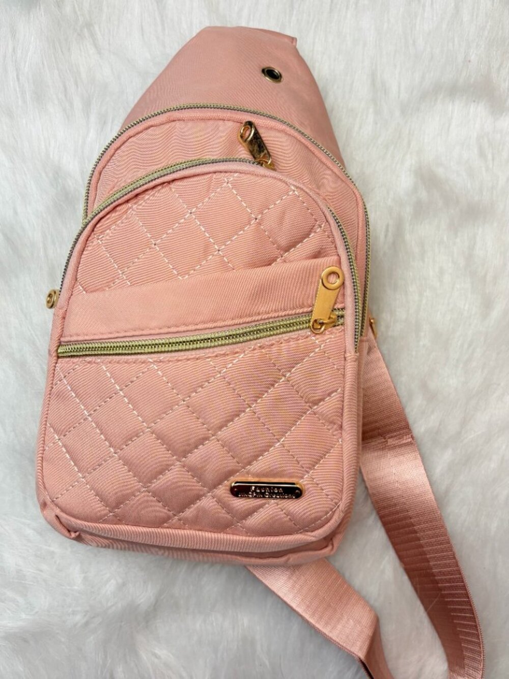 Pink quilted crossbody sling bag featuring a diamond-stitched front, gold-tone